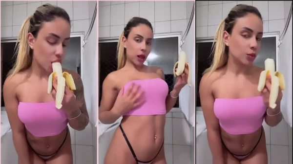 Lusia Fernanda de calcinha e top saboreando uma banana