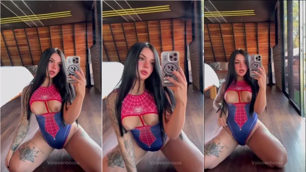 Valeeenbossa na frente do espelho, exibindo a retaguarda e os peitos